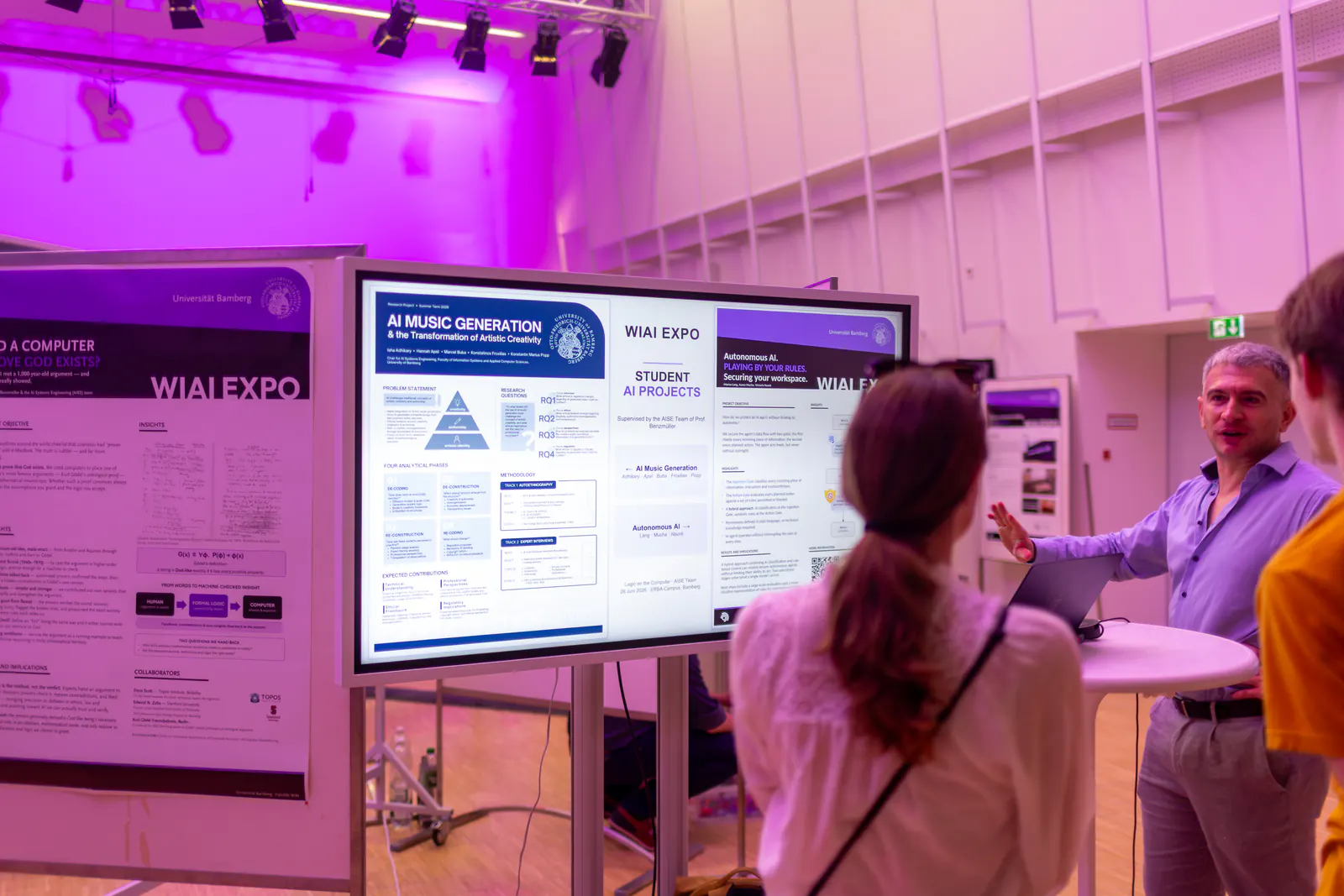 A man explains a large screen with English-language posters on student AI projects to a visitor